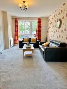 uma sala de estar com sofás e uma mesa de centro em The Naburn - 3 Bed House with Free Parking & Close to City Centre em Glasgow
