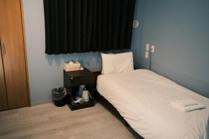 Postel nebo postele na pokoji v ubytování ホテルハーバー心斎橋