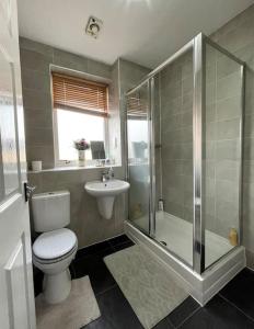 uma casa de banho com um WC, um chuveiro e um lavatório. em The Naburn - 3 Bed House with Free Parking & Close to City Centre em Glasgow