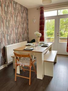 uma sala de jantar com uma mesa e uma cadeira em The Naburn - 3 Bed House with Free Parking & Close to City Centre em Glasgow