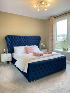 a large bed with a blue headboard in a bedroom at The Naburn - 3 Bed House with Free Parking & Close to City Centre in Glasgow