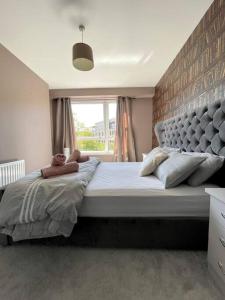 a bedroom with a large bed with a large window at The Naburn - 3 Bed House with Free Parking & Close to City Centre in Glasgow