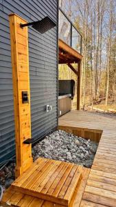 een klein gebouw met een terras en een veranda bij Lux Winter Getaway with Hot Tub, Sauna, EV charger in Haliburton