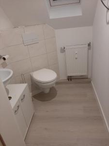 La salle de bains blanche est pourvue de toilettes et d'un lavabo. dans l'établissement Gemütliche Ferienwohnung der Familie Hüther, à Göttingen