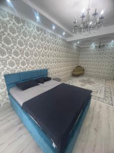 a bedroom with a blue bed and a wall at ЖК Green Plaza in Aktau