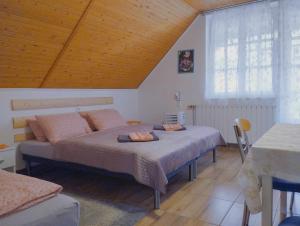 a bedroom with two beds and a wooden ceiling at Viola Apartmanház in Bogács