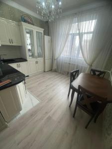 eine Küche mit einem Tisch und Stühlen sowie ein Esszimmer in der Unterkunft ЖК Green Plaza in Aqtau