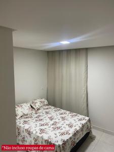 - une chambre dotée d'un lit avec un couvre-lit floral dans l'établissement Condomínio Everest Flat, à Caldas Novas
