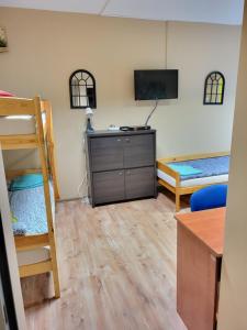 Zimmer mit einem Etagenbett und einem Schreibtisch mit einem TV in der Unterkunft Hostel Gliwice Centrum in Gliwice