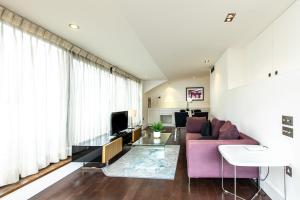 a living room with a purple couch and a tv at Contemporary Central London apartments in London