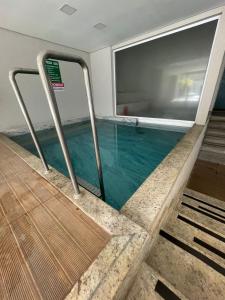 a swimming pool with blue water in a building at Condomínio Everest Flat in Caldas Novas
