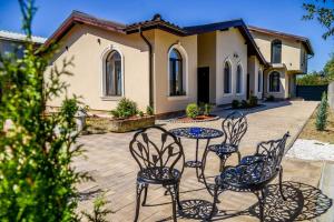 a patio with chairs and a table in front of a house at Villa Boutique Alina in Deva