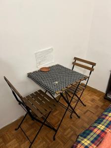 een tafel en twee stoelen naast een muur bij Habitacion doble en Figueres in Figueres