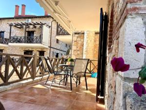 a patio with chairs and a table on a balcony at Boutique Stone House in Psakoudia