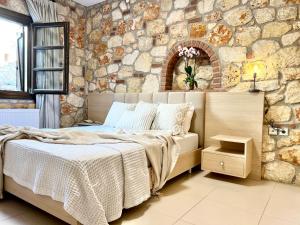 a bedroom with a bed and a stone wall at Boutique Stone House in Psakoudia