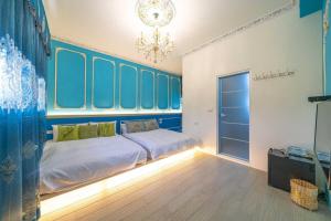 a bedroom with a bed with blue walls and a chandelier at Wei Yu's Home Villa in Dongshan