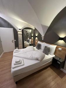 a bedroom with a large white bed and a mirror at Beb c’est lavis in Lavis