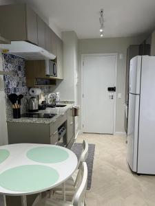 een keuken met een tafel en een witte koelkast bij STUDIO PROXIMO A PAULISTA in Sao Paulo