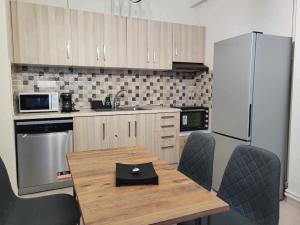 Orestiada的住宿－Μοντέρνο διαμέρισμα στο κέντρο，厨房配有木桌、椅子和冰箱
