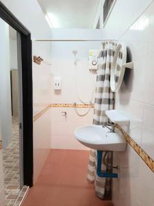 La salle de bains est pourvue d'un lavabo et d'une douche. dans l'établissement Rutcha homestay Betong รัชชา โฮมสเตย์ เบตง, à Betong
