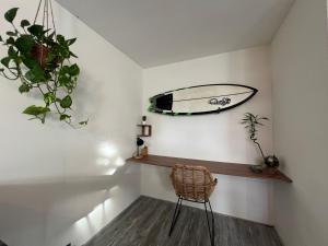 a room with a surfboard on the wall and a chair at Beach Apartment in Vlissingen