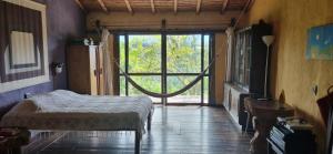 a bedroom with a bed and a large window at Finca La Colina in Armenia