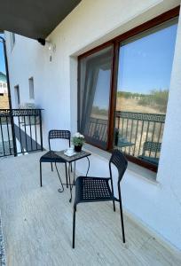 patio con 2 sillas, mesa y balcón en AmurResidence 641 privat-Sauna 3-Rooms free Parking, en Iaşi