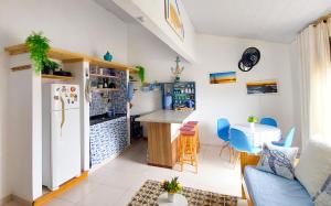 Casa Marítima Búzios- 200mt da Praia Piso Superior في بوزيوس: مطبخ وغرفة معيشة مع ثلاجة وطاولة