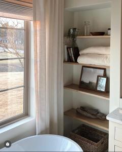een badkamer met een bad, een raam en een bed bij Southern Lake – Luxury Home in Texarkana in Texarkana