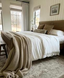 een slaapkamer met een groot bed met een deken erop bij Southern Lake – Luxury Home in Texarkana in Texarkana