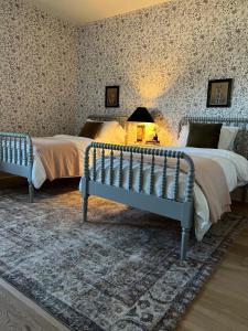 een slaapkamer met 2 bedden en een tafel met een lamp bij Southern Lake – Luxury Home in Texarkana in Texarkana