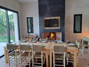 uma sala de jantar com uma mesa e uma lareira em Villa Rahma em Marrakech