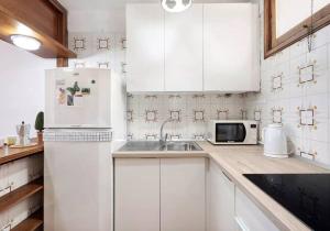 cocina blanca con fregadero y nevera en Costa Azul apartamento con vista, en Candelaria
