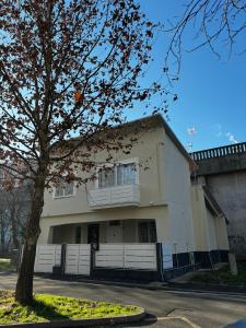 Una casa blanca con un árbol delante. en Villa Life en San Donato Milanese