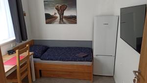 a small bedroom with a bed and a refrigerator at Apartmány Volavka in Planá nad Lužnicí