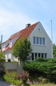 uma casa branca com um telhado vermelho em Sofort am Strand! em Kiel