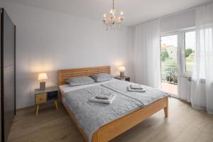een slaapkamer met een bed met twee handdoeken erop bij Villa More Mio in Poreč