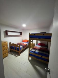 a bedroom with two bunk beds in a room at Lindo departamento en Punta Hermosa in Punta Hermosa
