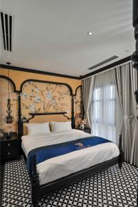 a bedroom with a large bed with a blue blanket at Thiên Ân Boutique Hotel in Bạc Liêu