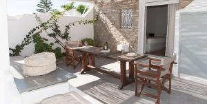a patio with a wooden table and chairs on a patio at Villa Mina in Adamantas