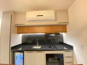 a kitchen with a sink and a stove at Flat Home Business 202 Centro Pomerode in Pomerode