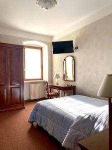 Schlafzimmer mit einem Bett, einem Schreibtisch und einem Fenster in der Unterkunft Albergo La Meridiana in Castelnuovo del Garda