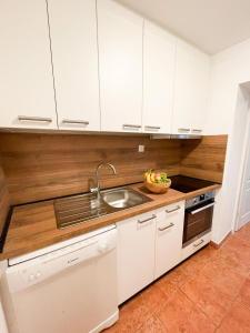 una cocina con armarios blancos y fregadero en Peaceful home in old village en Korčula