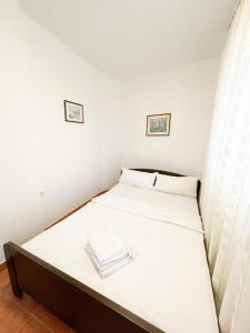 a small bedroom with a bed with white sheets at Peaceful home in old village in Korčula