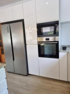 a kitchen with a refrigerator and a microwave at Finca Vista El Montanes in Málaga