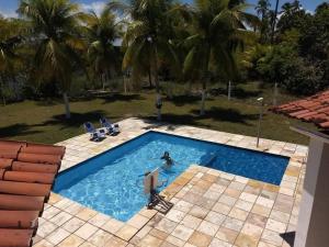 a person in a swimming pool in a resort at Paraiso Pasargada in Japaratinga