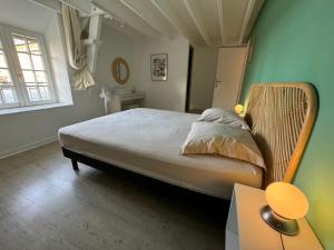 a bedroom with a large bed in a green wall at Chambres d'hôtes la Bégaudière in Dol-de-Bretagne