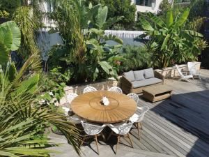 a patio with a wooden table and chairs at La petite Niçoise au Jacuzzi à 3 min de la mer in Nice