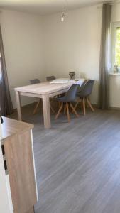 a wooden table in a room with chairs and a table at Ferienwohnung Christel in Erlenbach am Main