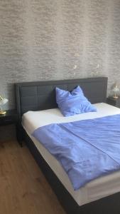 a bed with blue sheets and pillows in a bedroom at Ferienwohnung Christel in Erlenbach am Main